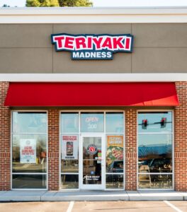 The outside of a pristine, and gorgeous looking Teriyaki Madness restaurant.